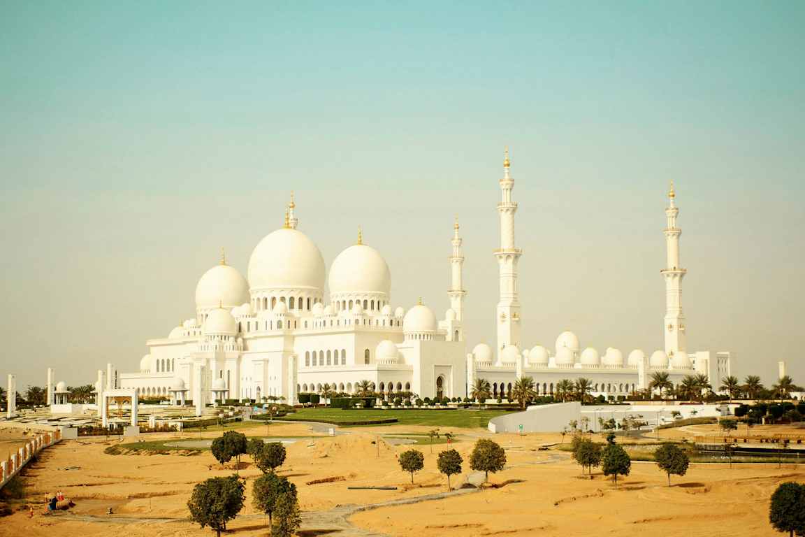 Suuri valkoinen moskeija, jossa on kupoleja ja minaretteja. (Tekoälyn luoma teksti)