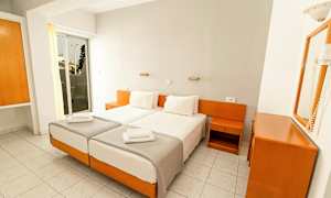 Kaksi yhden hengen vuodetta valkoisilla vuodevaatteilla hotellihuoneessa, jossa on valkoista ja puunsävyistä sisustusta. (Tekoälyn luoma teksti)