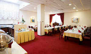 Ruokasalin sisätila, jossa on katetut pöydät, punaiset verhot ja buffet. (Tekoälyn luoma teksti)