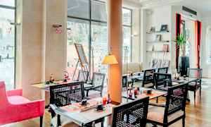 Ravintola, jossa on pöytiä ja tuoleja, koristeltu taiteella ja sisustuselementeillä. (Tekoälyn luoma teksti)