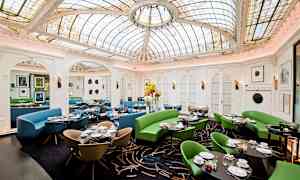 Ravintola, jossa on koristeellinen lasikatto ja värikkäitä huonekaluja. (Tekoälyn luoma teksti)