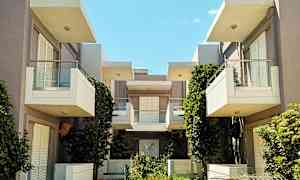 Moderni rakennus parvekkeilla ja vihreillä kasveilla. (Tekoälyn luoma teksti)