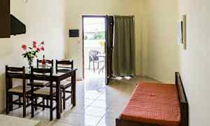 Huone, jossa on ruokapöytä ja tuolit, vuodesohva ja aukko parvekkeelle. (Tekoälyn luoma teksti)