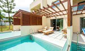 Yksityinen uima-allas, jossa aurinkotuoleja puisen pergolan alla. (Tekoälyn luoma teksti)