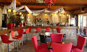 Baarin sisustus, punaisia tuoleja ja kiviseinä. (Tekoälyn luoma teksti)