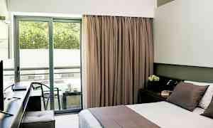 Hotellihuone, jossa on parivuode ja parveke istuinalueella. (Tekoälyn luoma teksti)