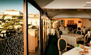 Ravintola lasiseinillä, näkymä rakennuksiin ja puihin. (Tekoälyn luoma teksti)