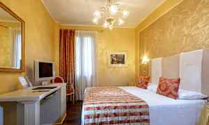 Hotellihuone, jossa parivuode, työpöytä televisiolla ja tuolilla sekä koristeellisia elementtejä. (Tekoälyn luoma teksti)