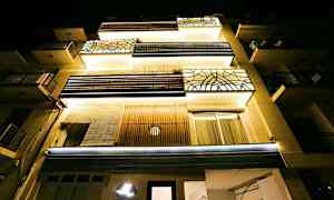 Asuinrakennus alhaalta kuvattuna yöllisessä valaistuksessa. (Tekoälyn luoma teksti)