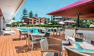 Ulkoalue, jossa uima-allas, aurinkotuoleja ja ruokailualue. (Tekoälyn luoma teksti)