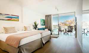 Kahden hengen huone, jossa vaalea sisustus ja parveke näköalalla. (Tekoälyn luoma teksti)