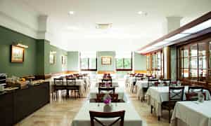 Ravintolan sisustus, jossa on katettuja pöytiä ja tuoleja. (Tekoälyn luoma teksti)