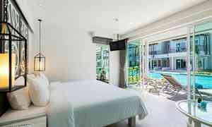 Hotellihuone, jossa pedattu sänky ja näkymä ulkona olevaan altaaseen. (Tekoälyn luoma teksti)