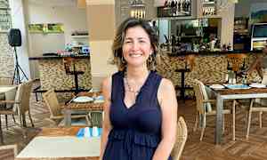 Ravintola, jossa aseteltuja pöytiä ja tuoleja sekä baaritiski taustalla. (Tekoälyn luoma teksti)