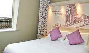 Hotellihuone, jossa suuri sänky, violetit tyynyt ja yksityiskohtainen seinämaalaus sängyn takana. (Tekoälyn luoma teksti)