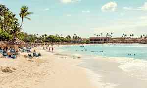 Hiekkaranta palmuineen ja aurinkotuoleineen, ihmiset uivat ja kävelevät, ja meri ulottuu kirkkaan taivaan alle. (Tekoälyn luoma teksti)