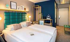 Hotellihuone, jossa on parivuode, moderni sisustus ja kaappi henkareilla. (Tekoälyn luoma teksti)