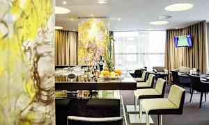 Hotellibaari, jossa on tyylikkäät sisustukset ja modernit kalusteet. Asiakkaille on tarjolla pöytiä ja tuoleja. (Tekoälyn luoma teksti)