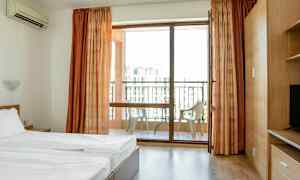 Hotellihuone, jossa sänky ja parveke tuoleineen. (Tekoälyn luoma teksti)