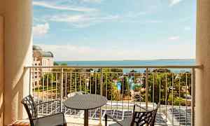 Näkymä parvekkeelta merelle, etualalla tuolit ja pöytä. (Tekoälyn luoma teksti)