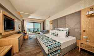 Hotellihuone, jossa on moderni sisustus, parivuode ja parveke merinäköalalla. (Tekoälyn luoma teksti)