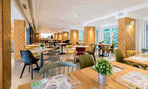 Kuva ravintolasta, jossa on pöytiä, tuoleja ja koristeita. (Tekoälyn luoma teksti)