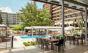 Hotellin ulkoalue, jossa uima-allas ja istumapaikkoja katoksen alla. (Tekoälyn luoma teksti)