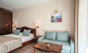 Huone, jossa on parivuode, sohva, puupöytä ja seinäkoriste. (Tekoälyn luoma teksti)