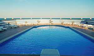 Uima-allas aurinkotuoleineen ja sininen taivas. (Tekoälyn luoma teksti)