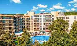 Hotellialue, jossa on kerrostaloja, suuri ulkouima-allas ja vihreitä puita etualalla. (Tekoälyn luoma teksti)