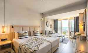 Hotellihuone, jossa parivuode, istuma-alue ja parveke merinäköalalla. (Tekoälyn luoma teksti)