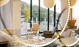 Moderni huone, jossa istuimet ja sohvat, suuret ikkunat, jotka avautuvat terassille. (Tekoälyn luoma teksti)