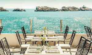Ravintolaterassi merinäköalalla, pöydät ja tuolit ovat katettuja. (Tekoälyn luoma teksti)