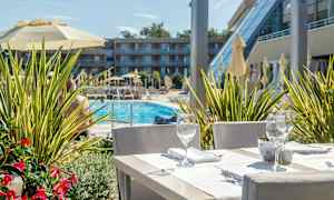 Pöytä katettuna, taustalla näkymä altaalle ja rakennukseen. (Tekoälyn luoma teksti)