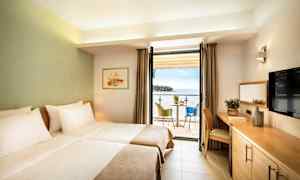 Hotellihuone, jossa on kaksi yhden hengen vuodetta, parveke merinäköalalla ja istuinryhmä. (Tekoälyn luoma teksti)