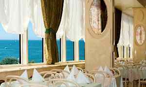 Ravintola, jossa on katettuja pöytiä ikkunan edessä merinäköalalla. (Tekoälyn luoma teksti)