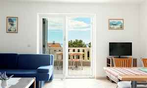 Olohuone, jossa sininen sohva ja ruokapöytä, vieressä parveke merinäköalalla. (Tekoälyn luoma teksti)