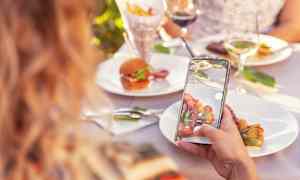 Henkilö ottaa kuvan ruokalautasesta ulkopöydällä. (Tekoälyn luoma teksti)