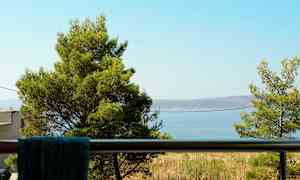 Näkymä parvekkeelta, jossa puita ja meri taustalla. (Tekoälyn luoma teksti)