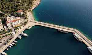 Ilmakuva satamasta, jossa on veneitä ja viereisiä rakennuksia. (Tekoälyn luoma teksti)