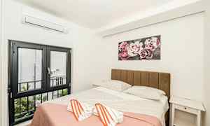 Makuuhuone, jossa on parivuode, koristeltuna seinällä olevan kukkamaalauksen kanssa. (Tekoälyn luoma teksti)