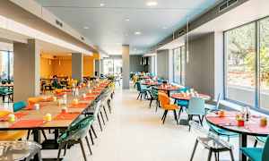 Ruokasali värikkäillä tuoleilla ja kattauksella. (Tekoälyn luoma teksti)