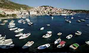 Rannikolla oleva kaupunki veneineen satamassa ja rakennuksineen taustalla. (Tekoälyn luoma teksti)