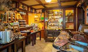 Ravintolan tai kahvilan sisustus, jossa on buffettipöytä ja viinipulloja hyllyssä. (Tekoälyn luoma teksti)