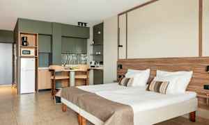 Huone, jossa sänky, pöytä ja keittonurkkaus. (Tekoälyn luoma teksti)