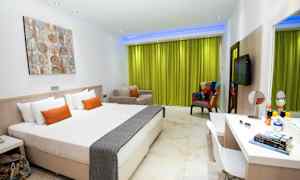 Moderni hotellihuone, jossa on valkoinen sisustus ja vihreä verho. (Tekoälyn luoma teksti)