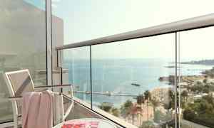 Näkymä parvekkeelta merelle, mukana tuoli, pöytä ja aikakauslehti. (Tekoälyn luoma teksti)