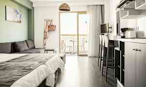 Moderni hotellihuone, jossa on vuodesohva, sänky, keittiövälineet ja parveke näköalalla. (Tekoälyn luoma teksti)