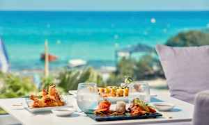 Pöytä meren äärellä, sushi ja muita aasialaisia ruokia. (Tekoälyn luoma teksti)