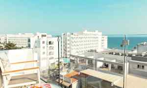 Näköala parvekkeelta, jossa on tuoleja ja pöytä, hotellirakennuksia ja meri taustalla. (Tekoälyn luoma teksti)